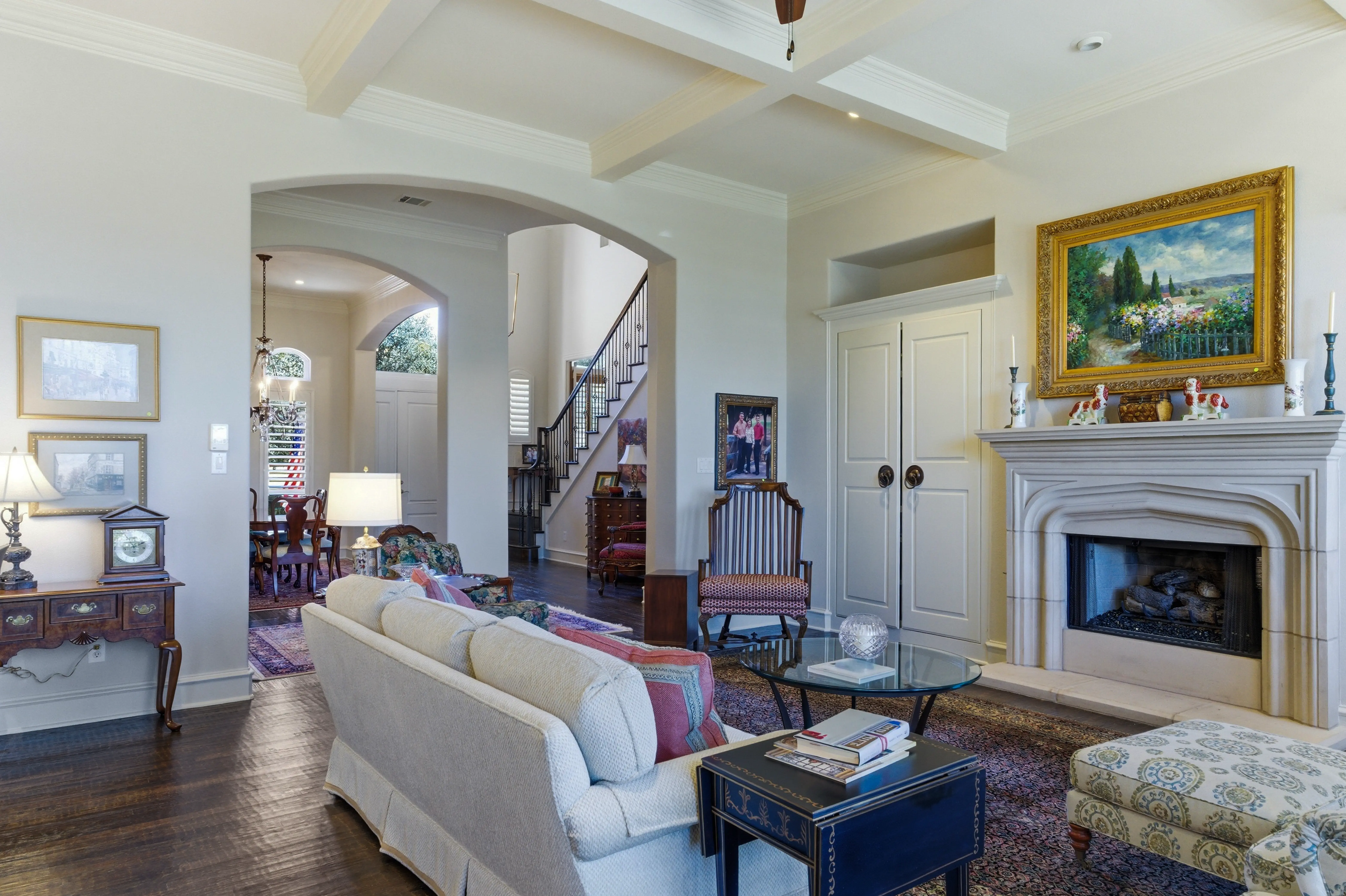 Grand living room with coffered beam ceilings, gas fireplace, and hardwood floors